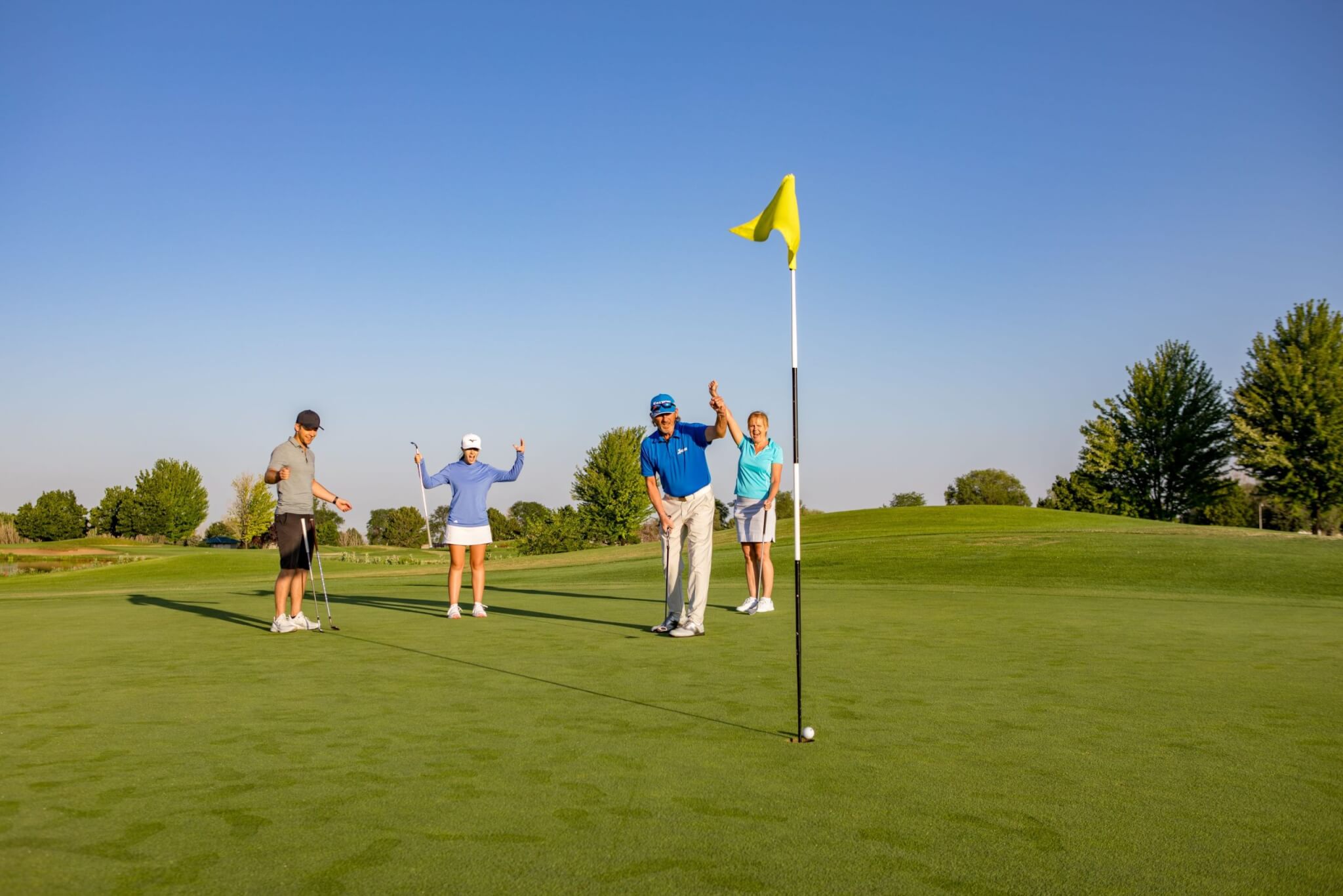 Group of people enjoying outdoor recreation while golfing on a sunny day at a scenic golf course in Nampa, Idaho.